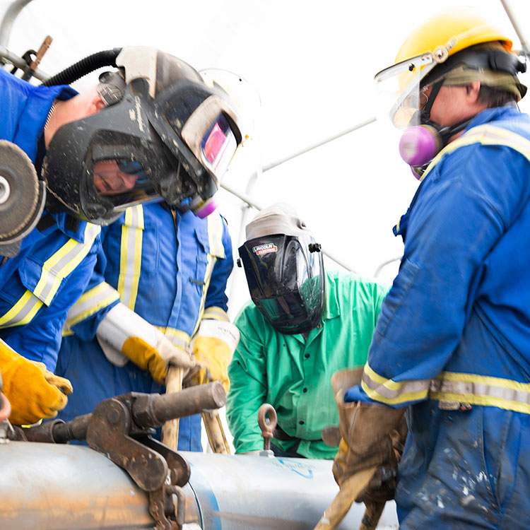 Les soudeurs travaillent sur un segment exposé du pipeline pendant les activités d'entretien régulières.