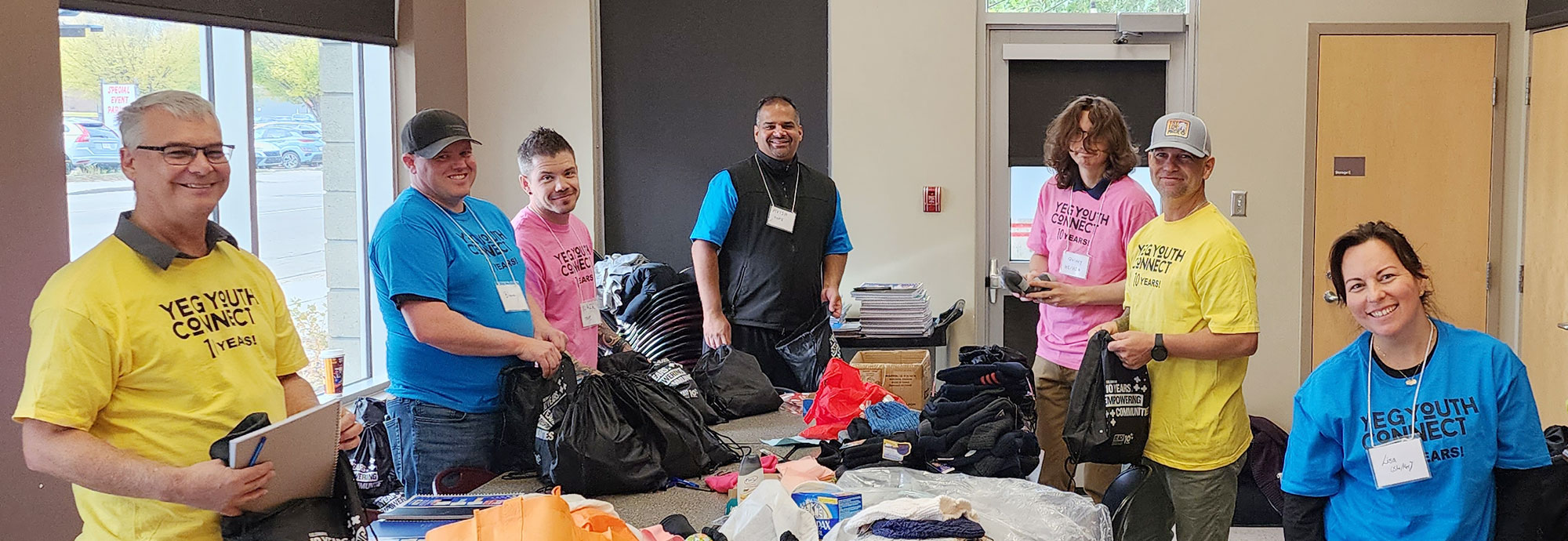 Un groupe d'employés et d'autres bénévoles préparent des trousses pour les participants à l'événement YEG Youth Connect à Edmonton.